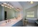 Bathroom featuring double vanity sinks, a freestanding tub, and modern lighting at 3217 New Rutledge Nw Rd, Kennesaw, GA 30152