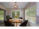 Bright breakfast nook features a round table, bright windows, and an elegant modern light fixture at 3217 New Rutledge Nw Rd, Kennesaw, GA 30152