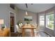 Bright dining room with a long table, a modern light fixture, and expansive windows overlooking the backyard at 3217 New Rutledge Nw Rd, Kennesaw, GA 30152