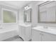 Well-lit bathroom featuring double vanities, a soaking tub, and modern fixtures for a spa-like experience at 4002 Laurel Bend Dr, Snellville, GA 30039