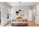 Stylish dining area with rustic wood table, bench seating, pendant lighting, and modern wall mirrors at 1347 Elderwood Way, Cumming, GA 30041
