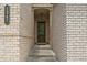 Close-up of a charming home entry, featuring a detailed brick facade and a welcoming glass-paneled door at 1347 Elderwood Way, Cumming, GA 30041