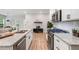 Modern kitchen featuring granite countertops, stainless steel appliances, and sleek white cabinetry with a large sink at 1347 Elderwood Way, Cumming, GA 30041