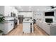 Open-concept kitchen with white cabinets, stainless steel appliances, and a view of the living area and fireplace at 1347 Elderwood Way, Cumming, GA 30041