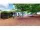 Backyard is fenced, landscaped with mature trees and pine mulch at 2058 Bonneville Ln, Powder Springs, GA 30127