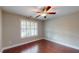 Comfortable bedroom with hardwood floors, ceiling fan, and a window with stylish plantation shutters at 2058 Bonneville Ln, Powder Springs, GA 30127