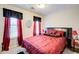 Bedroom featuring a queen-sized bed, red linens, side tables, and natural light at 2121 Silva Ct, Conley, GA 30288