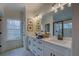 Bright bathroom features double sinks, vanity with drawers, and a large mirror over a stone countertop at 220 Nicklaus Cir, Social Circle, GA 30025