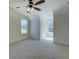 Spacious bedroom with plush carpeting, natural light, and a ceiling fan at 220 Nicklaus Cir, Social Circle, GA 30025