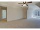 Spacious bedroom featuring neutral carpet, a ceiling fan, and a window offering natural light at 220 Nicklaus Cir, Social Circle, GA 30025