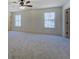 Spacious bedroom featuring neutral carpet, a ceiling fan, and two windows offering natural light at 220 Nicklaus Cir, Social Circle, GA 30025