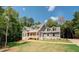 Beautiful home with a large yard surrounded by lush trees at 220 Nicklaus Cir, Social Circle, GA 30025