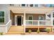 Inviting front porch featuring a classic design with white columns and wooden steps at 220 Nicklaus Cir, Social Circle, GA 30025