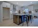 Modern kitchen with white cabinets, a large island, and black stools on light colored hardwood floors at 220 Nicklaus Cir, Social Circle, GA 30025