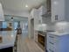 Modern kitchen featuring stainless steel appliances, white cabinets, and wood flooring at 220 Nicklaus Cir, Social Circle, GA 30025