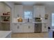 White kitchen cabinets with stainless steel dishwasher and view to deck at 220 Nicklaus Cir, Social Circle, GA 30025