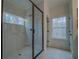 Elegant walk-in shower with marble tile, glass door, and modern fixtures at 220 Nicklaus Cir, Social Circle, GA 30025