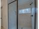Elegant walk-in shower with marble tile, glass door, and modern fixtures at 220 Nicklaus Cir, Social Circle, GA 30025