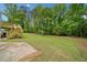 A spacious backyard with a deck, lush greenery, and a concrete area at 2920 Alberta Dr, Marietta, GA 30062
