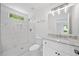 Bright, updated bathroom with a marble tile shower and white vanity with granite top at 2920 Alberta Dr, Marietta, GA 30062