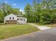 Charming white home with stone accents, manicured lawn, and driveway, nestled amongst lush trees at 2920 Alberta Dr, Marietta, GA 30062