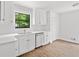 Bright kitchen featuring white cabinets, countertops and stainless steel dishwasher, with natural light from window at 2920 Alberta Dr, Marietta, GA 30062