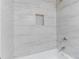 Clean, updated bathroom shower with light gray tile and tiled shower niche at 5857 Earlwane Dr, Lithonia, GA 30058