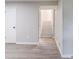 View of bedroom with light gray walls and light wood flooring leading to staircase at 5857 Earlwane Dr, Lithonia, GA 30058