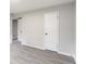 The bedroom with light gray walls and light wood flooring has a white door at 5857 Earlwane Dr, Lithonia, GA 30058