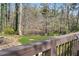 Picture taken from deck shows backyard view with pond, seating, and wooded area at 65 Deer Run Ln, Mcdonough, GA 30252