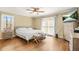 A bright bedroom with hardwood floors, a ceiling fan, and large windows creates a comfortable and inviting atmosphere at 65 Deer Run Ln, Mcdonough, GA 30252