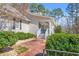 Charming home entrance with brick pathway, covered porch with fan, and lush green landscaping at 65 Deer Run Ln, Mcdonough, GA 30252