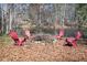 Inviting fire pit area with four Adirondack chairs overlooking a tranquil pond, perfect for outdoor gatherings at 65 Deer Run Ln, Mcdonough, GA 30252