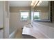 Bright bathroom features white tile, a pedestal sink, a large vanity mirror, and a shower/tub combo at 87 Virgil Sw St, Mableton, GA 30126