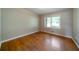 The light and airy bedroom has hardwood floors, neutral walls and trim, and a large window at 87 Virgil Sw St, Mableton, GA 30126