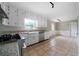 Bright kitchen features white cabinets, subway tile backsplash, stainless steel appliances, and granite countertops at 87 Virgil Sw St, Mableton, GA 30126