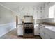 The updated kitchen features white cabinets, granite countertops, stainless steel appliances, and tile floors at 87 Virgil Sw St, Mableton, GA 30126
