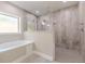 Bathroom features separate tub and tiled shower with rainfall shower head and window at 150 Whitworth Dr, Locust Grove, GA 30248