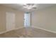 A bright bedroom boasts neutral walls, carpet, a ceiling fan, and natural light from an open doorway at 150 Whitworth Dr, Locust Grove, GA 30248