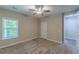 A neutral toned bedroom featuring plush carpet, a ceiling fan, and natural light from the window at 150 Whitworth Dr, Locust Grove, GA 30248
