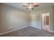 A bright bedroom with neutral colors and a ceiling fan leads to bathroom and walk-in closet at 150 Whitworth Dr, Locust Grove, GA 30248