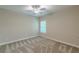 Neutral bedroom with grey carpet, a ceiling fan, and natural light from a large window at 150 Whitworth Dr, Locust Grove, GA 30248