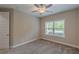 A cozy bedroom featuring neutral walls, carpet, a ceiling fan, and natural light from a window at 150 Whitworth Dr, Locust Grove, GA 30248