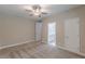 A bright bedroom with grey carpet features a ceiling fan, neutral walls, and an adjacent bathroom at 150 Whitworth Dr, Locust Grove, GA 30248