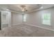 Large bedroom boasts neutral carpet, tray ceiling, fan, and windows that let in natural light at 150 Whitworth Dr, Locust Grove, GA 30248