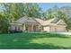 Beautiful brick home with a well-kept lawn and a wide driveway leading to a two-car garage at 150 Whitworth Dr, Locust Grove, GA 30248