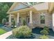 Inviting front porch with stone pillars and landscaped garden beds enhance the curb appeal of this brick home at 150 Whitworth Dr, Locust Grove, GA 30248