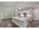Modern kitchen features a large island with quartz countertops, white cabinets and stainless steel appliances at 150 Whitworth Dr, Locust Grove, GA 30248