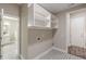 Laundry room featuring patterned tile flooring and overhead shelving, with access to additional rooms at 150 Whitworth Dr, Locust Grove, GA 30248