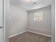 This bedroom offers soft carpeting, light gray walls, and natural light from the window at 1879 Rosewood Rd, Decatur, GA 30032
